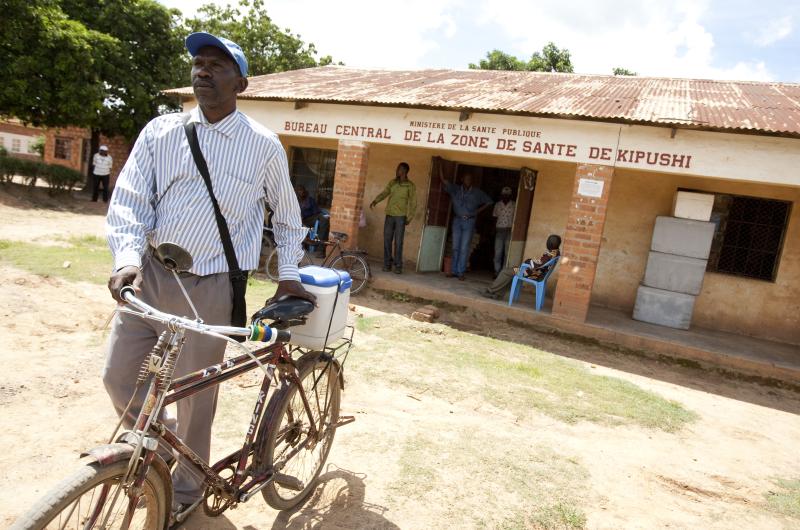 Assistant nurse Guy Bakatumaka pushes a bicycle carrying an icebox full of vaccines in DRC.